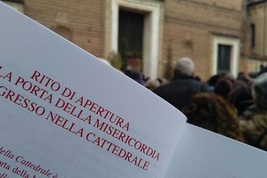 La folla attende che i battenti del portale principale del duomo vengano aperti dal vescovo Claudio