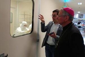 Alchimia - il vescovo guarda attraverso il vetro gli operai nella stanza sterile