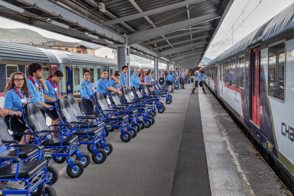 Una delegazione di scout spagnoli aspetta i malati al momento dell’arrivo alla stazione di Lourdes.