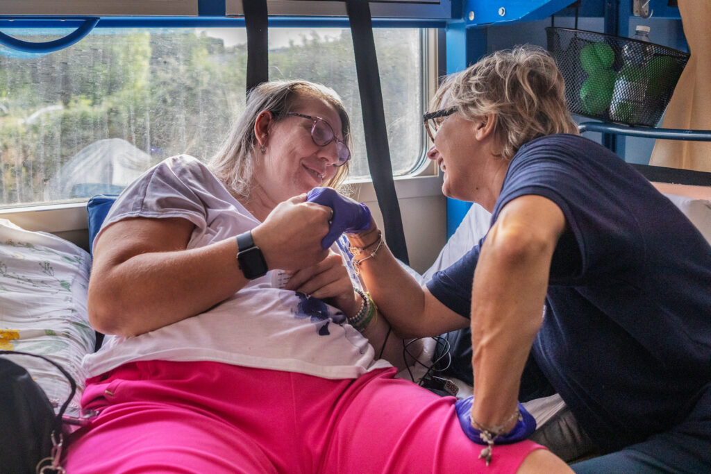 Un’infermiera sorride a una delle persone accomodate nei vagoni attrezzati durante il viaggio.