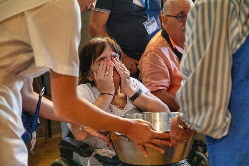 Una pellegrina durante il rituale del gesto dell’acqua.